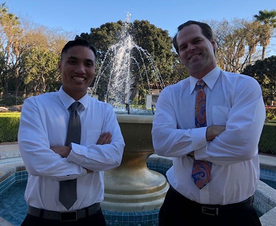 Dr. Acasio & Dr. Carson in front of office fountain.